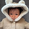 baby, child, coat, hood, fur, ears, cute, face, portrait, warm_clothing, button, infant, looking, soft_texture, curious, indoor, person, young, closeup, adorable