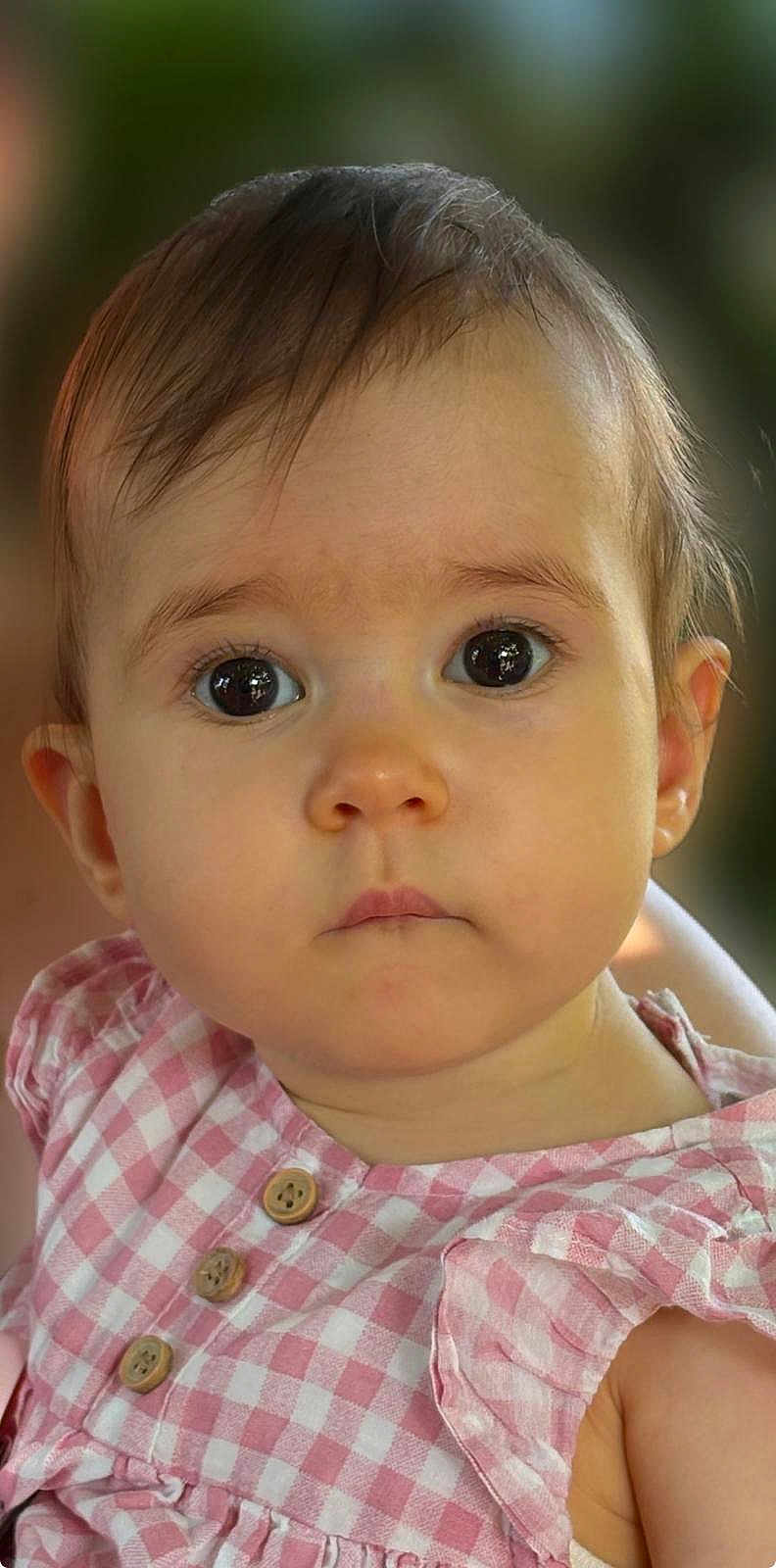 Camélia participe au concours pour gagner de l'argent avec cette photo : baby, child, face, portrait, closeup, pink_dress, checkered_pattern, buttons, curious_expression, wide_eyes, soft_lighting, short_hair, infant, cute, skin, ear, person, indoor, young_child, clothing
