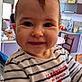 Camélia participe au concours pour gagner de l'argent avec cette photo : baby, child, smiling, striped_shirt, indoor, kitchen, person, young_child, face, happy, cute, holding, hand, furniture, table, chair, appliance, window, light, home