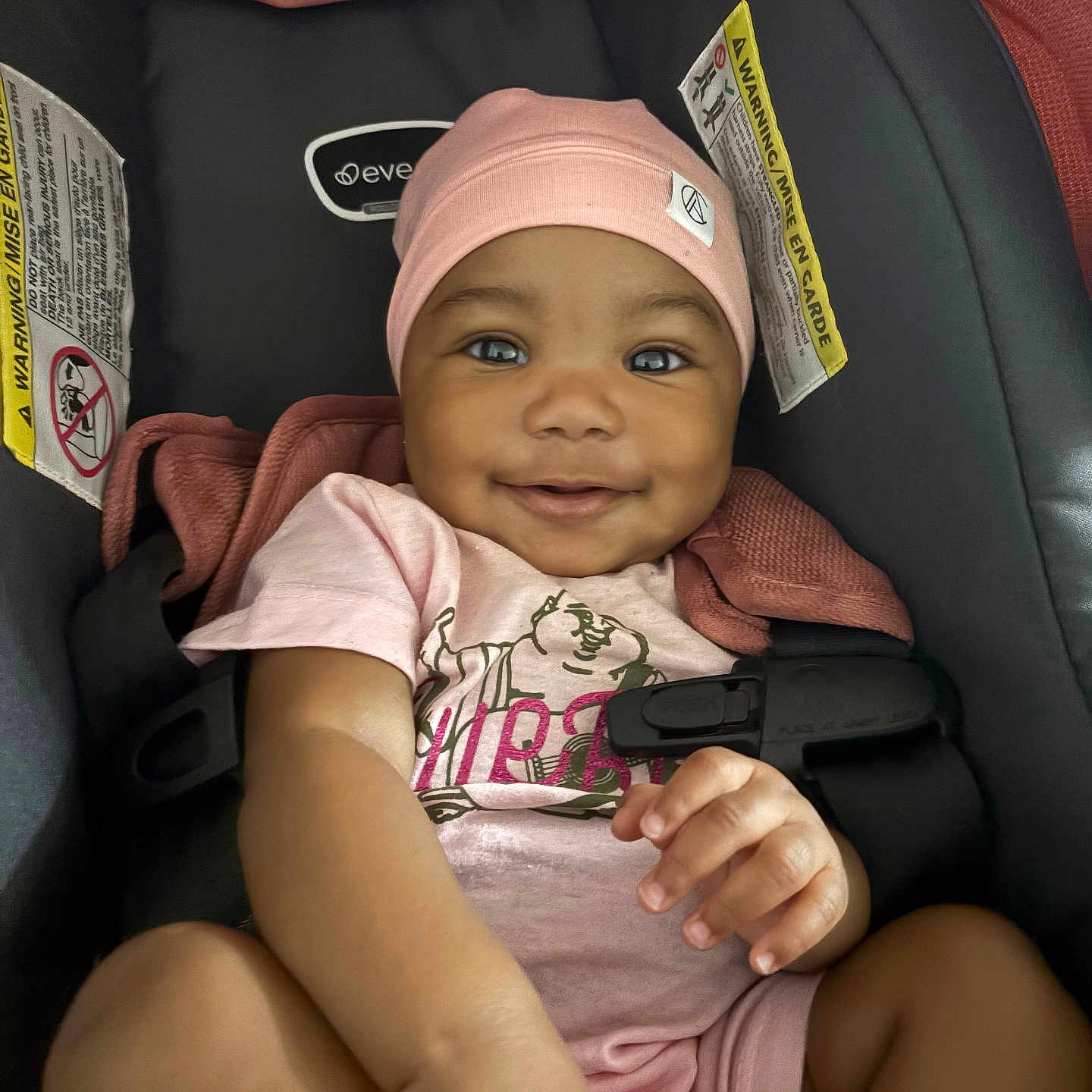 Deoni joined the competition — help win amazing prizes! baby, baby_clothes, car_seat, child, closeup, clothing, cute, face, hand, happy, indoor, infant, person, pink_hat, pink_onesie, portrait, seatbelt, skin, smiling, young_child