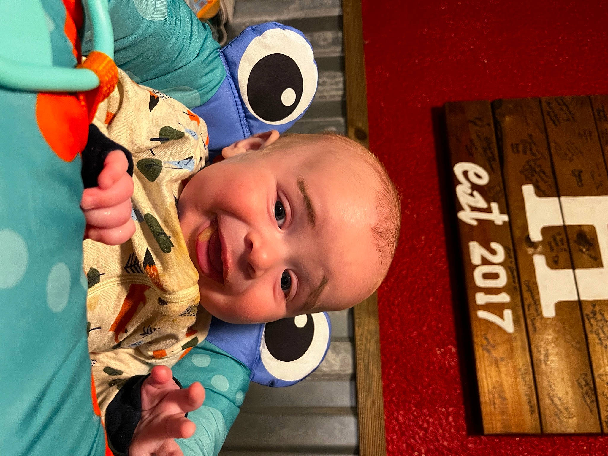 Ozzy is registered to the contest to win money with this photo: art, baby, baby_products, baby_toddler_clothing, child, eyewear, fun, happy, house, leisure, mouth, nose, orange, person, personal_protective_equipment, play, room, smile, toddler, toy