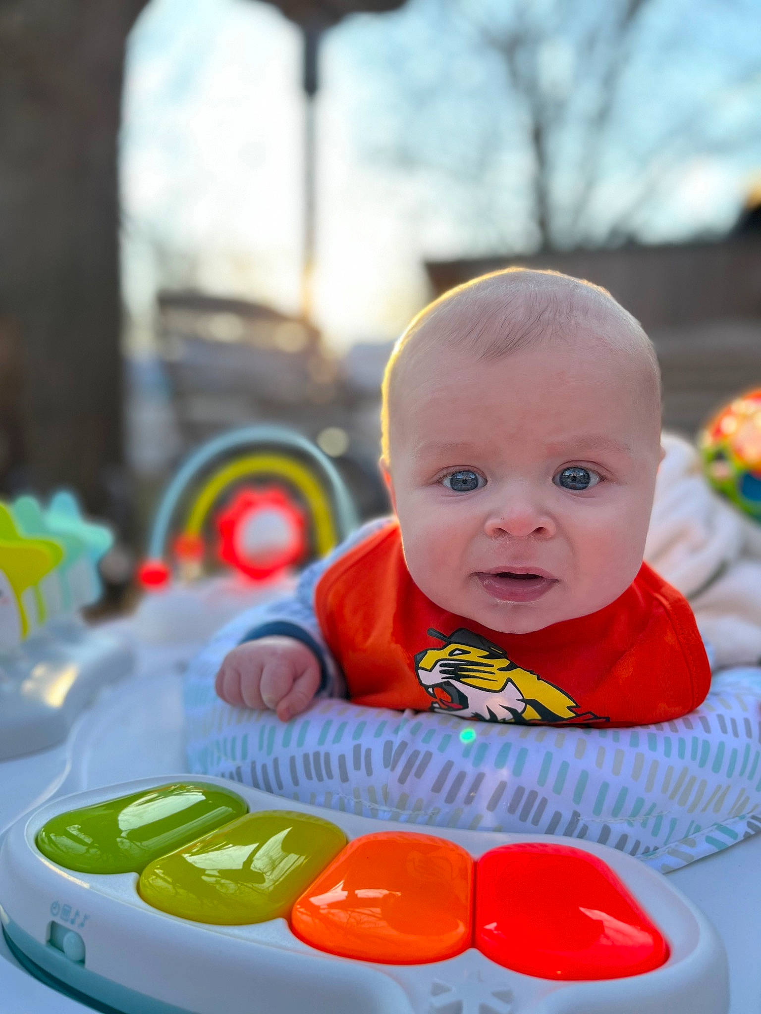 Ozzy is registered to the contest to win money with this photo: baby, baby_playing_with_toys, baby_products, baby_toddler_clothing, bib, cheek, child, facial_expression, fun, grass, happy, iris, leisure, orange, person, product, recreation, sitting, skin, sky