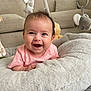 baby, smiling, face, infant, plush_toy, giraffe, elephant, cushion, pink_clothing, happy, indoor, person, child, soft_toy, head, cute, lying_down, furniture, home, bright