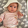 Amber is registered to the contest to win money with this photo: baby, infant, hat, white_hat, striped_shirt, rainbow_patch, pink_pants, cloud_pattern, mat, lying_down, cute, child, indoors, soft_lighting, portrait, person, small_hands, wide_eyes, clothing, baby_toy