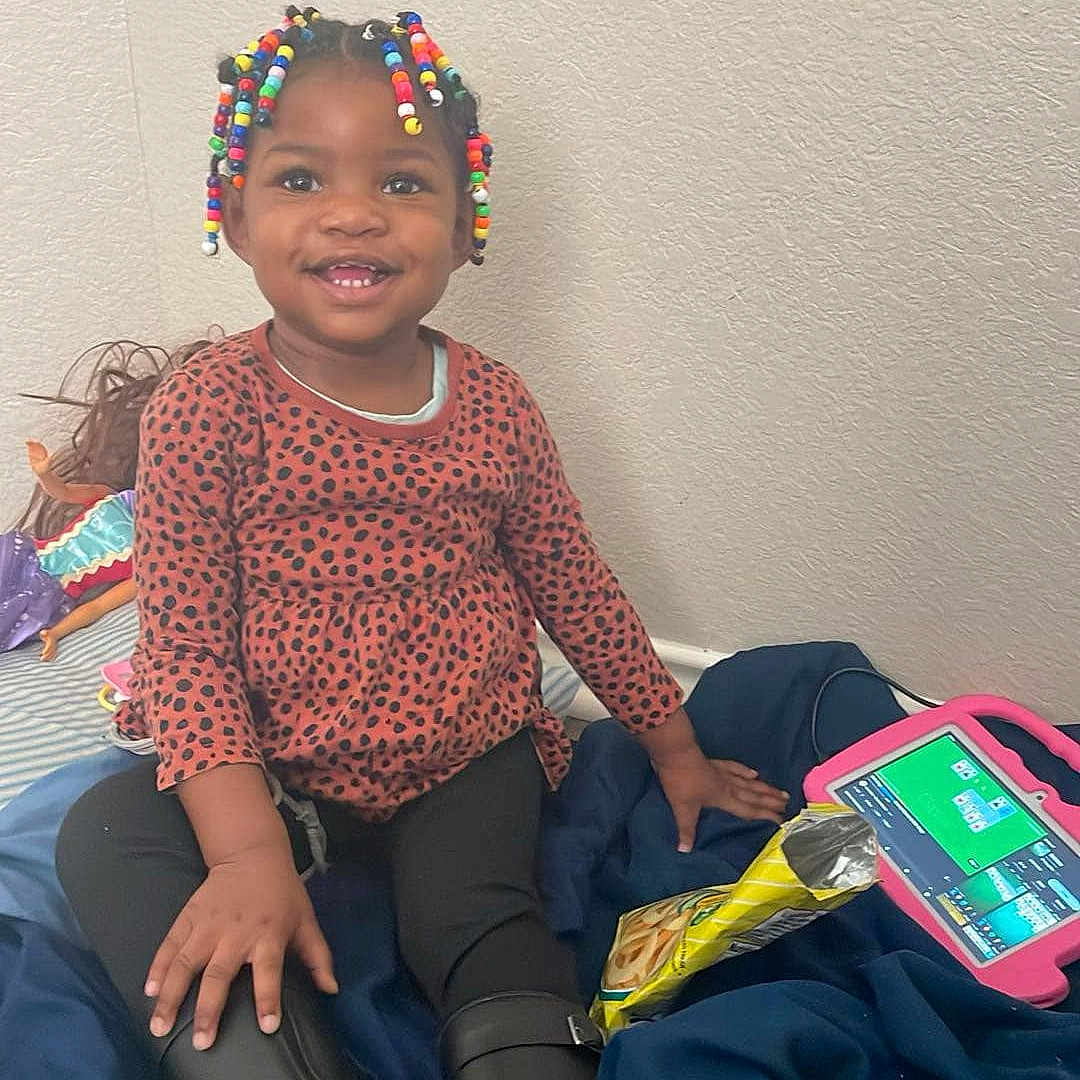 Ahnylah joined the competition — help win amazing prizes! child, clothing, couch, cushion, electronics, face, female, furniture, girl, happy, head, homedecor, pants, person, phone, photography, portrait, sitting, sleeve, smile