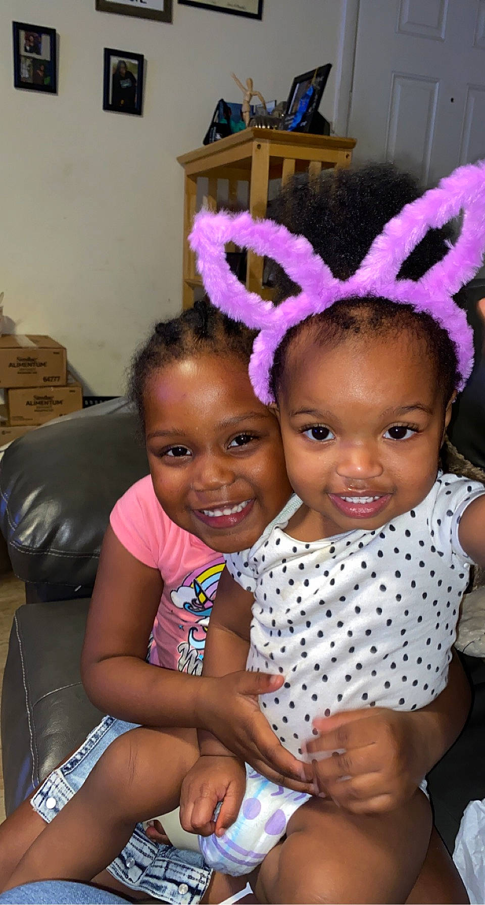 Yormani is registered to the contest to win money with this photo: baby_toddler_clothing, black, child, event, facial_expression, fun, hairstyle, happy, head, joy, mammal, organ, party_supply, people, person, picture_frame, pink, purple, sharing, smile