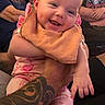 Dahlia joined the competition — help win amazing prizes! baby, smiling, tattoo, pajamas, bib, hand, indoor, elderly_man, young_man, furniture, living_room, family, person, footwear, pink, happy, holding, sitting, portrait, casual