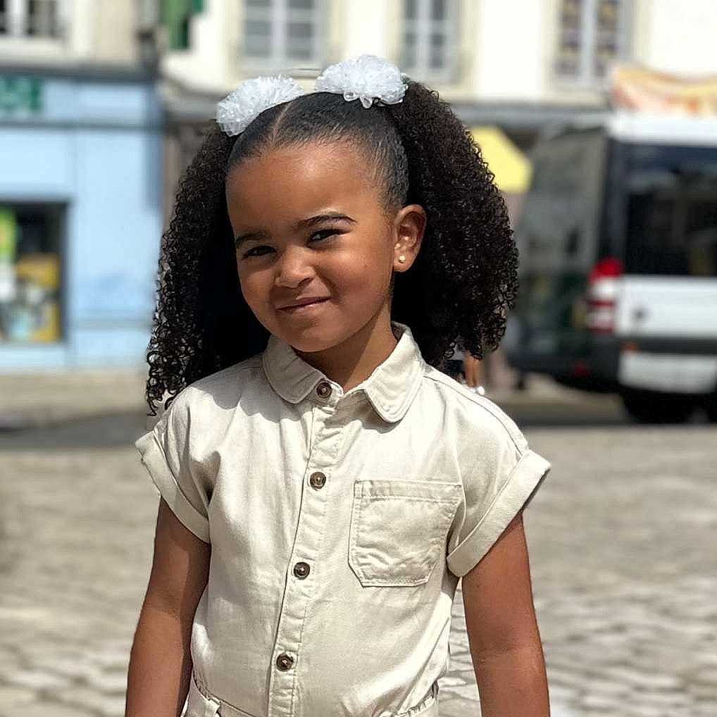 Kélya a rejoint le concours — aidez-le/la à gagner de superbes lots ! beauty, black_hair, car, child, eye, fashion_accessory, fun, gesture, happy, jewellery, joy, lip, neck, person, school_uniform, skin, sleeve, smile, street, t_shirt