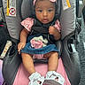 Alayah is registered to the contest to win money with this photo: baby, child, car_seat, pink_bow, headband, denim_dress, white_sandals, sitting, straps, indoor, face, person, cute, infant, clothing, footwear, seat, safety, baby_accessory, portrait