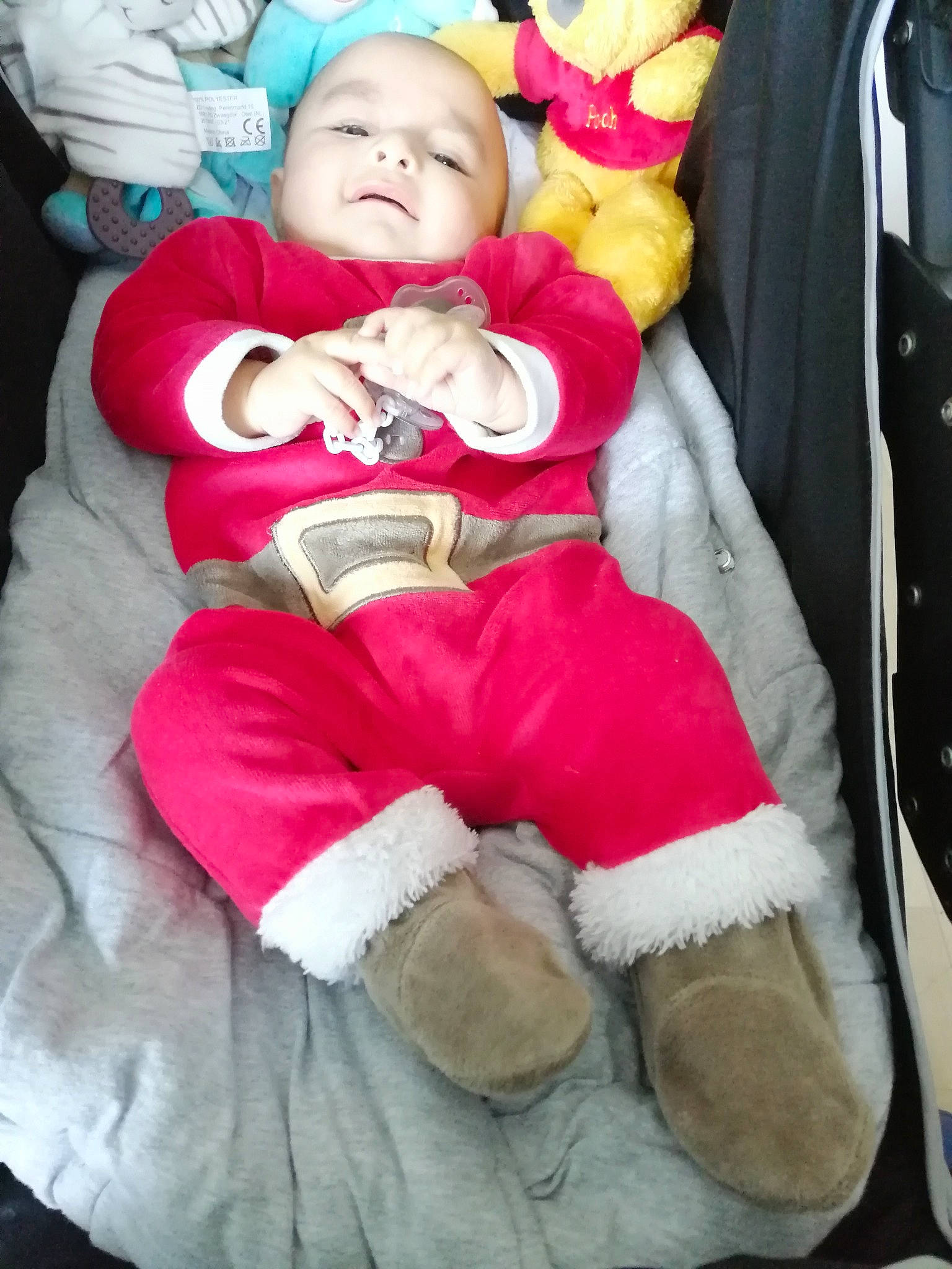 Kenzo participe au concours pour gagner de l'argent avec cette photo : baby, baby_toddler_clothing, carmine, cheek, child, comfort, event, fictional_character, fun, fur, happy, lap, person, pink, red, santa_claus, sitting, sock, textile, toddler