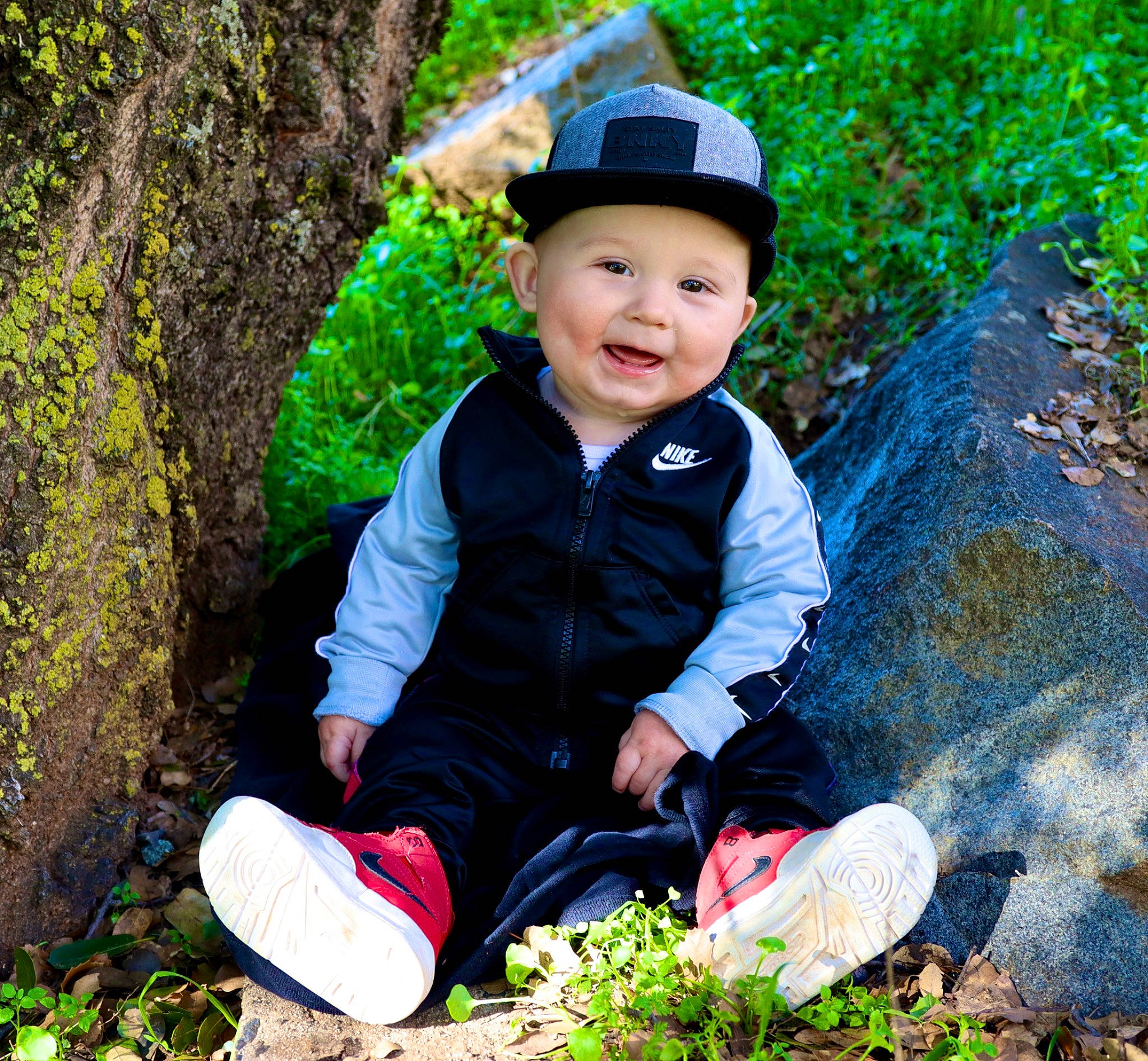 Abel Odin is registered to the contest to win money with this photo: baby_toddler_clothing, botany, cap, eye, face, grass, happy, hat, head, headgear, headwear, jacket, leaf, nature, people_in_nature, person, plant, shoe, sleeve, smile