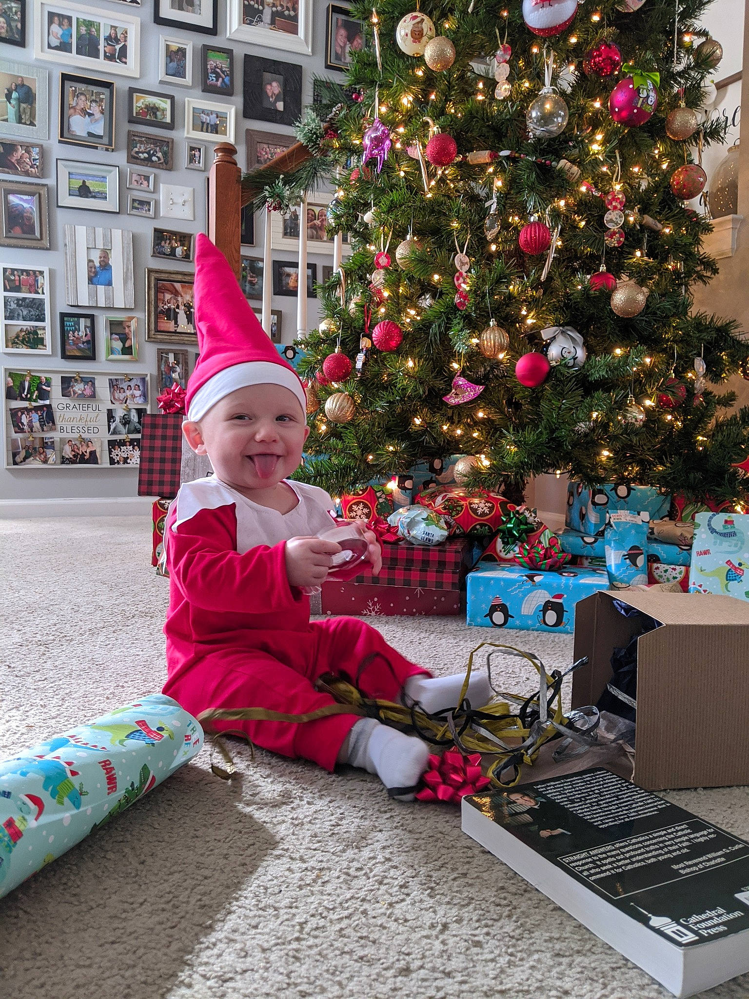 Graham is registered to the contest to win money with this photo: child, christmas, christmas_decoration, christmas_eve, christmas_ornament, christmas_tree, event, fictional_character, fir, happy, headwear, holiday, home, interior_design, joy, person, plant, room, santa_claus, sitting
