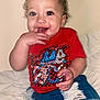 Journi joined the competition — help win amazing prizes! toddler, child, smiling, red_shirt, denim_shorts, curly_hair, hair_bows, indoor, bed, happy, person, cute, sitting, playful, fingers_in_mouth, casual_clothing, young_child, face, portrait, skin