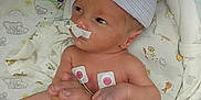 Caspen is registered to the contest to win money with this photo: newborn, baby, hospital, medical_equipment, hand, finger, diaper, beanie, sensor, monitoring, patient, infant, skin, person, care, holding, bed, cute, healthcare, tiny
