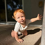 Axel is registered to the contest to win money with this photo: baby, carpet, child, crawling, curious, expression, floor, home, indoor, light, natural_light, onesie, person, portrait, reaching, red_hair, shadow, skin, toddler, young_child