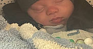 Waylon is registered to the contest to win money with this photo: baby, sleeping, blanket, hat, cozy, infant, face, closeup, warm, soft, child, cute, resting, indoors, headwear, peaceful, bundle, comfort, portrait, newborn