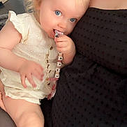 Charlize a rejoint le concours — aidez-le/la à gagner de superbes lots ! toddler, child, blue_eyes, hair_clip, pacifier_clip, snuggling, adult, black_dress, indoor, cute, baby, hand, face, skin, person, close_up, comfort, holding, seated, light