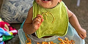 Theodore joined the competition — help win amazing prizes! toddler, child, baby, high_chair, bib, pasta, food, messy, smiling, indoors, carpet, plate, face, hand, happy, sitting, meal, clothing, person, cute