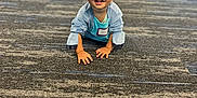 Theodore joined the competition — help win amazing prizes! blurred_background, carpet, child, clothing, crawling, face, floor, furniture, happy, head, indoor, jacket, jeans, name_tag, people, person, room, shoes, smiling, toddler