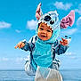 baby, blue, child, clouds, costume, cute, ears, face, fun, hands, happy, jumping, ocean, outdoor, playful, portrait, sky, stitch, toddler, water