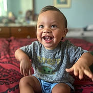 Tyrone is registered to the contest to win money with this photo: baby_yoda, bed, bedspread, child, clothing, cute, drawer, face, furniture, happy, indoor, mirror, person, room, shirt, shorts, skin, smiling, toddler, toy