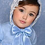 child, toddler, portrait, bonnet, lace, satin_bow, blue_dress, ribbon, hazel_eyes, long_eyelashes, rosy_cheeks, soft_skin, face, head, clothing, studio_background, innocence, cute, pose, closeup