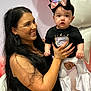 woman, baby, child, balloons, party, smile, black_shirt, white_pants, headband, long_hair, indoor, celebration, holding, happy, portrait, people, casual_clothing, pink, white, accessory