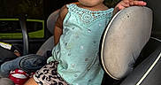 Jaycie is registered to the contest to win money with this photo: toddler, child, car_seat, clothing, shorts, top, curly_hair, indoor, vehicle, seat, person, cute, expression, sunlight, window, car, footwear, nike, patterned_clothing, portrait