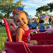Jaycie joined the competition — help win amazing prizes! toddler, child, smile, red_wagon, outdoor, grass, trees, sunlight, people, gathering, blue_sky, hair_bows, red_clothing, park, daytime, play, happy, cute, fun, summer