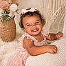 baby, blanket, bow, candid, child, cozy, curly_hair, cute, decor, expression, flower_vase, furniture, happy, indoor, knitted, pink_dress, portrait, smiling, soft_lighting, toddler