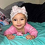 baby, infant, child, smiling, headband, pink_clothing, blanket, pacifier, bed, pillow, minnie_mouse, cartoon, cute, happy, indoors, portrait, toddler, soft_toys, cozy, lying_down