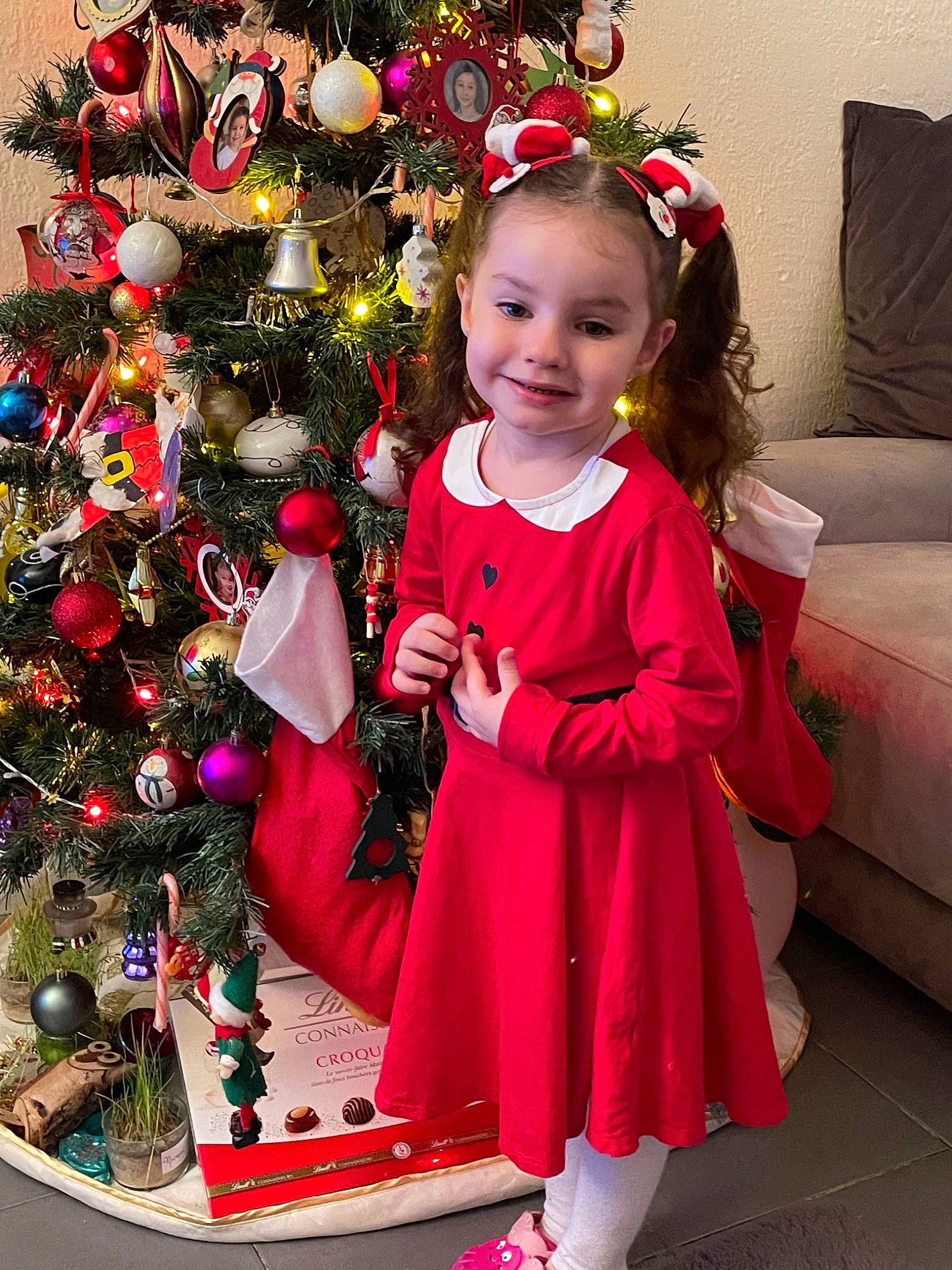 Mélody a rejoint le concours — aidez-le/la à gagner de superbes lots ! baby_toddler_clothing, beauty, christmas_decoration, christmas_ornament, christmas_tree, dress, event, happy, head, holiday_ornament, human_body, joy, ornament, person, pink, plant, red, sleeve, smile, snapshot