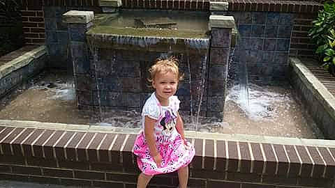 Kaylynn is registered to the contest to win money with this photo: baby_toddler_clothing, child, composite_material, day_dress, fun, happy, leisure, magenta, person, sitting, smile, toddler, travel, vacation, water, water_feature