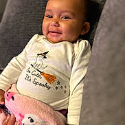 Mo'Hana is registered to the contest to win money with this photo: baby, smiling, infant, blanket, pink, cute, shirt, halloween, witch_hat, broom, stars, indoor, couch, cozy, child, happy, portrait, clothing, person, hand