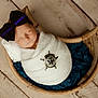 newborn, baby, sleeping, wrapped, blanket, bow, headband, badge, sheriff, wooden_bowl, blue_cloth, floor, rustic, cozy, portrait, indoor, peaceful, infant, cute, soft