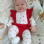 Skylar-Rose is registered to the contest to win money with this photo: baby, infant, smile, red_clothing, white_clothing, headband, heart_pattern, blanket, teddy_bear_pattern, butterfly_pattern, sitting, happy, cute, child, indoor, soft_texture, playful, person, footwear, portrait