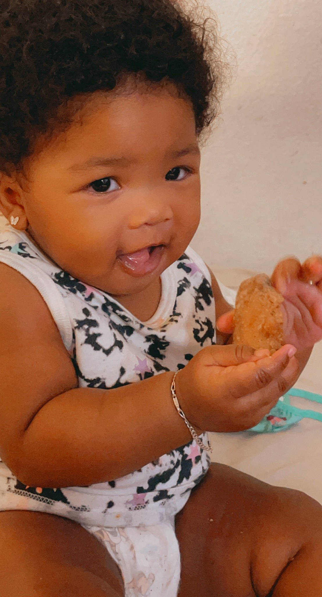 Kylah is registered to the contest to win money with this photo: arm, baby, baby_toddler_clothing, baked_goods, cheek, child, cuisine, dessert, eyelash, finger, finger_food, food, gesture, hand, happy, organ, person, skin, smile, thumb