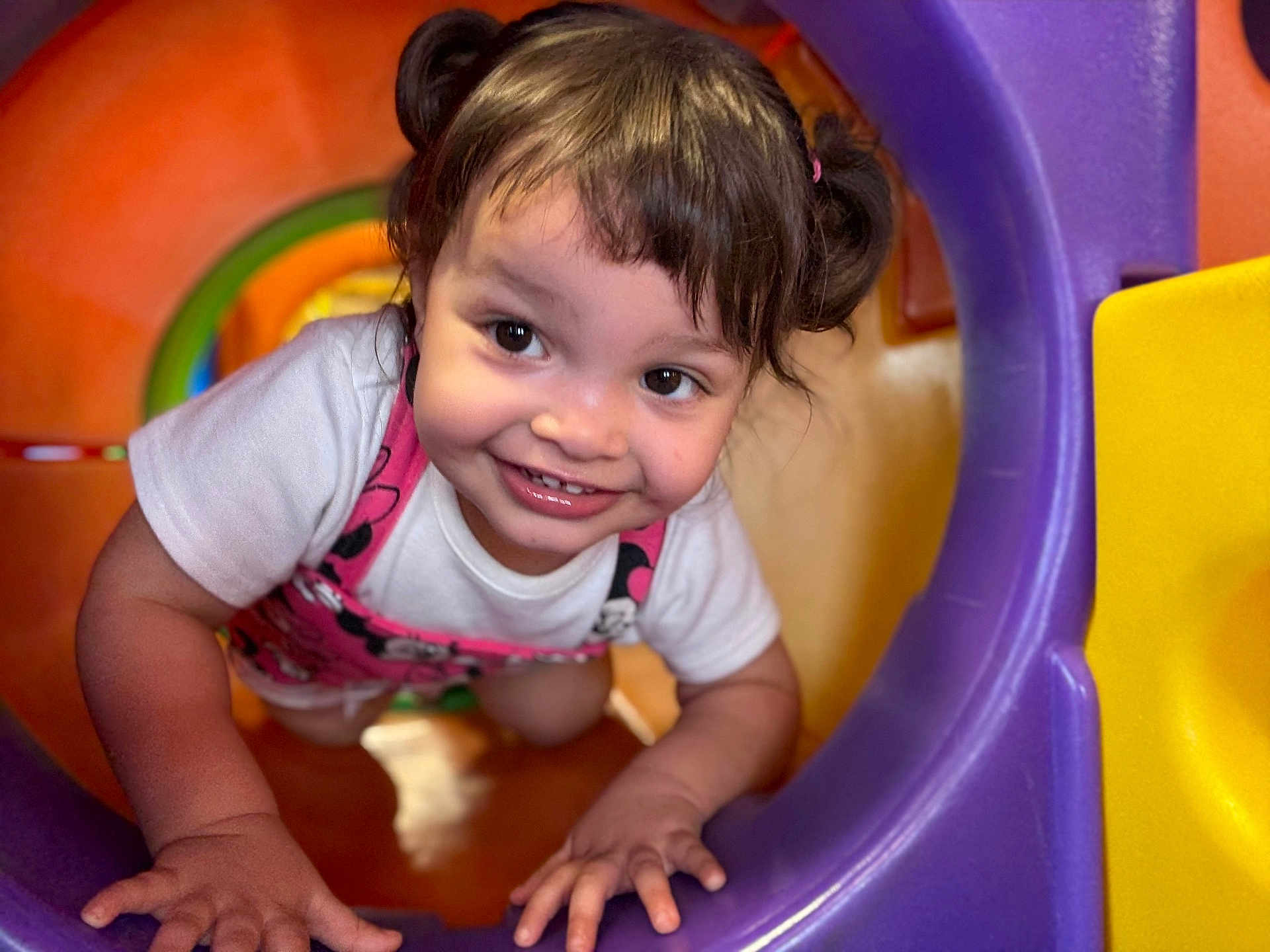 Gianna joined the competition — help win amazing prizes! toddler, child, smiling, pigtails, playground, plastic, colorful, crawling, happy, face, white_shirt, pink_overall, indoor, toy, fun, cute, young_child, play, curious, hands