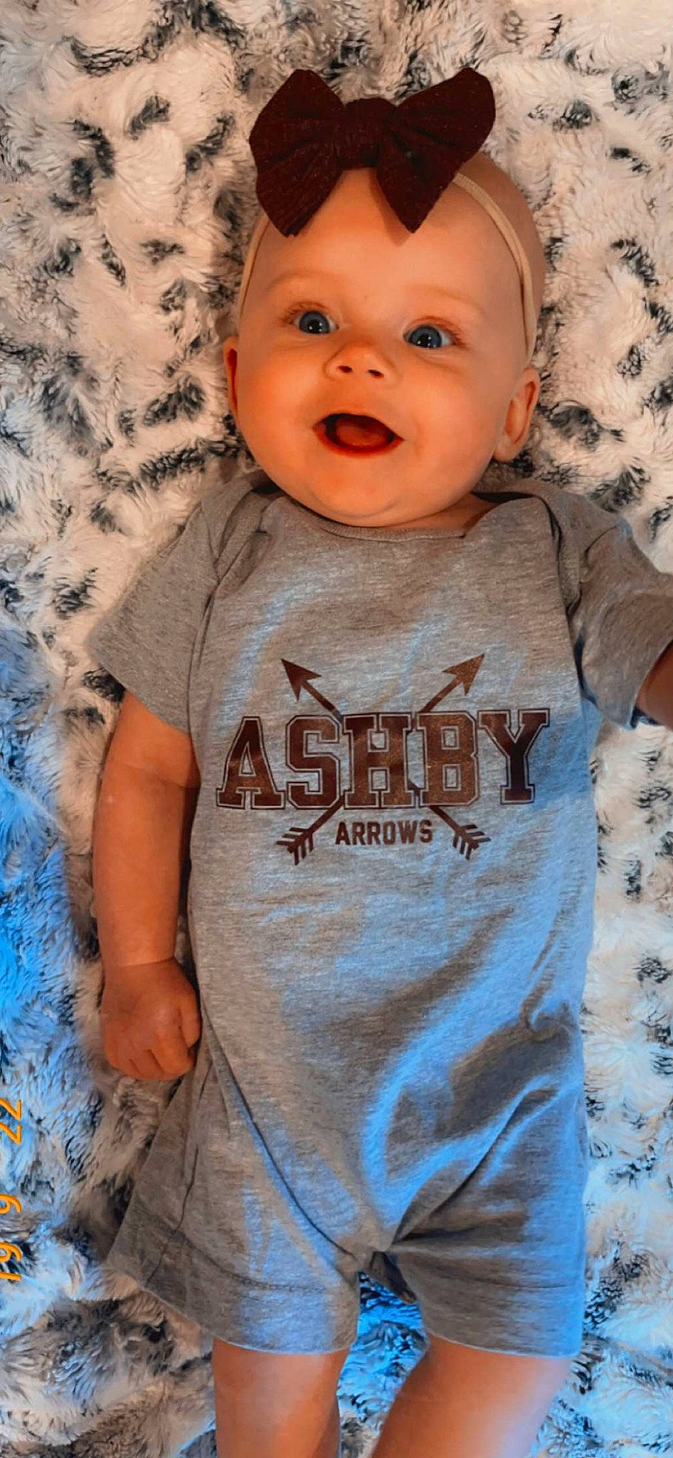 Harlow is registered to the contest to win money with this photo: arm, baby, baby_toddler_clothing, blue, cheek, chin, eye, face, grey, happy, head, iris, lip, mouth, neck, nose, person, skin, sleeve, smile