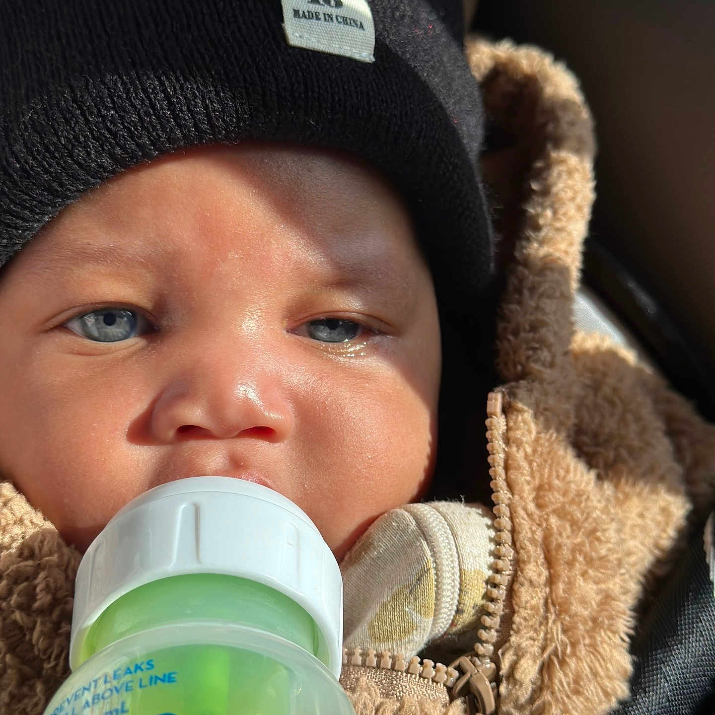 Kejohn joined the competition — help win amazing prizes! baby, blue_eyes, bottle, close_up, cozy_clothing, fuzzy_jacket, hat, infant, light, mouth, pacifier, person, portrait, skin, soft_texture, sunlight, warm_clothing, wearing, young_child, zipper