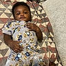 Asante joined the competition — help win amazing prizes! baby, child, infant, couch, blanket, patterned_blanket, teddy_bear_print, onesie, pacifier, hand, foot, indoors, fabric, furniture, portrait, cute, relaxed, lying_down, skin, face