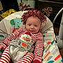 baby, baby_rocker, carpet, child, colorful_pattern, cute, festive, furniture, happy, headband, holiday, indoor, infant, portrait, red_striped_pajamas, reindeer, santa_claus, seatbelt, smiling, tinsel