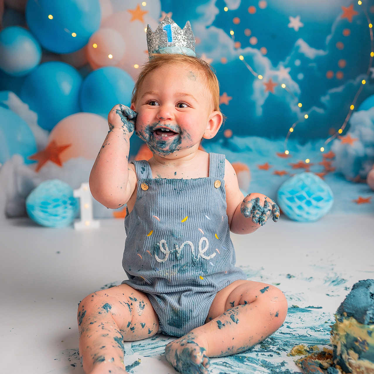 Vinnie is registered to the contest to win money with this photo: accessories, baby, bodypart, clothing, dress, face, finger, hand, happy, hat, head, jewelry, person, photography, portrait, shorts, sitting, smile, sphere, turquoise