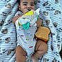 Benjamin joined the competition — help win amazing prizes! baby, infant, blanket, plush_toy, stuffed_animal, toy, smiling, cute, child, patterned_blanket, clothing, onesie, barefoot, lying_down, happy, face, head, legs, hand, outdoor