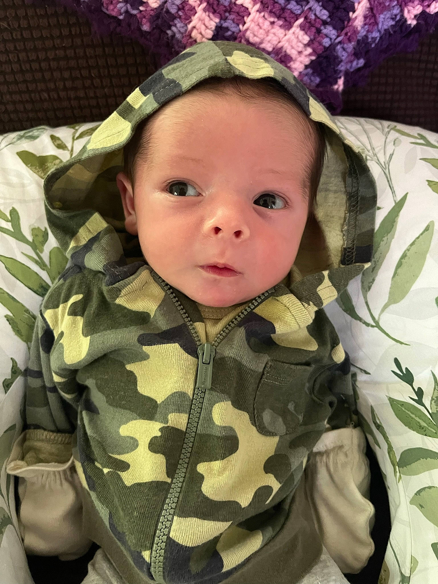 Sebastian is registered to the contest to win money with this photo: baby, baby_toddler_clothing, camouflage, cheek, cool, eye, eyebrow, facial_expression, head, headgear, human_body, iris, military_camouflage, military_uniform, outerwear, pattern, person, skin, sleeve, textile