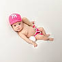 Ariel joined the competition — help win amazing prizes! baby, infant, crocheted_hat, pink_hat, baseball_cap, baseball_bat, baseball, diaper_cover, soft_surface, white_background, cute, portrait, child, laying_down, props, hand, foot, looking_at_camera, indoor, adorable