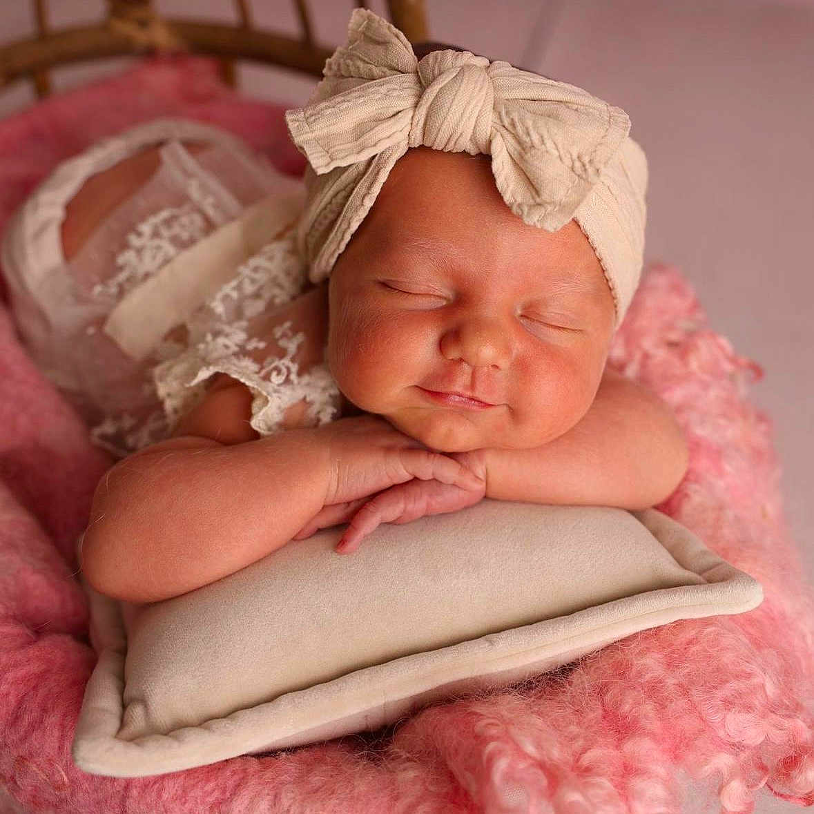 Lou participe au concours pour gagner de l'argent avec cette photo : baby, newborn, sleeping, headband, bow, pillow, blanket, wicker_chair, pink, soft_texture, peaceful, infant, cute, portrait, resting, closeup, child, indoors, cozy, adorable