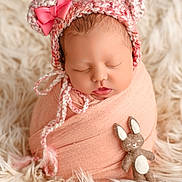 Lou a rejoint le concours — aidez-le/la à gagner de superbes lots ! newborn, baby, sleeping, knitted_hat, bear_ears, pink_bow, blanket, soft_texture, fluffy_rug, felt_toy, bunny, cute, wrapped, portrait, infant, peaceful, cozy, child, indoors, adorable