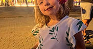 Théa a rejoint le concours — aidez-le/la à gagner de superbes lots ! background, casual_clothing, child, evening, flower, fun, girl, happy, light, nature, outdoor, people, person, portrait, public_space, sidewalk, smile, street, tree, urban