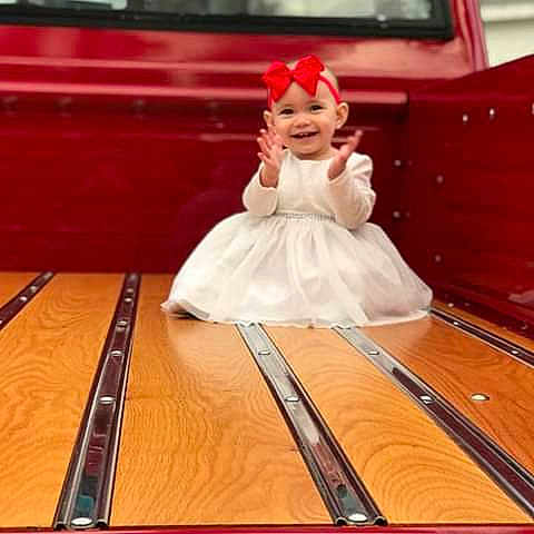 Madelynn is registered to the contest to win money with this photo: bridal_clothing, child, dress, floor, flooring, furniture, girl, gown, joy, person, product, red, table